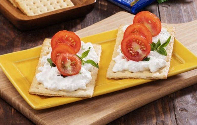 Cracker com creme de queijo e tomatinho