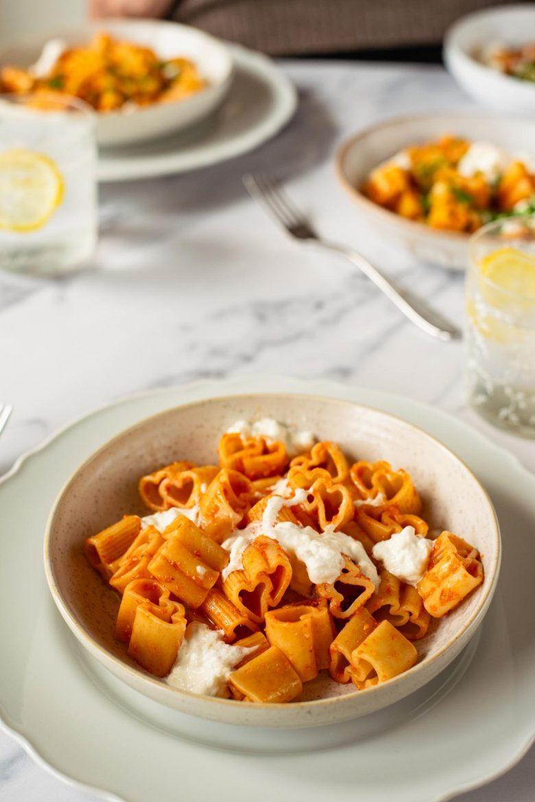 Pasta love com creme de tomate confit, óleo de manjericão, frutas cítricas e burrata
