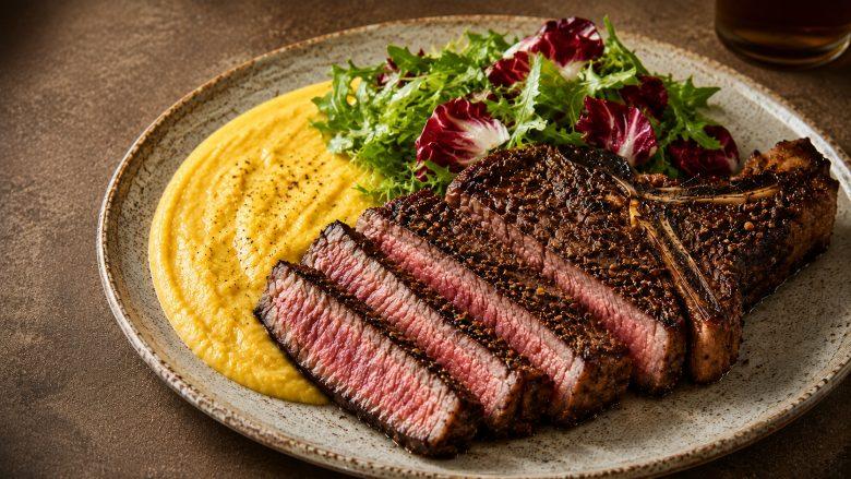 Coffee crusted ribeye steak, purê de milho com queijo canastra e salada de folhas amargas